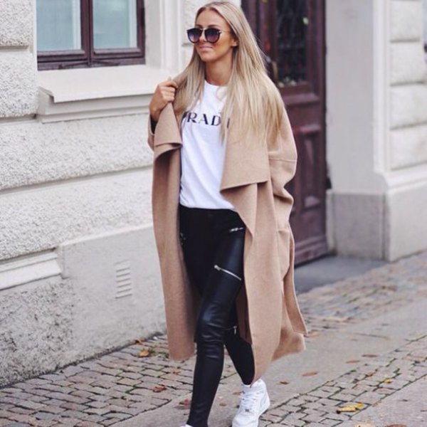 Camel colored maxi winter coat with white printed t-shirt and black leather pants