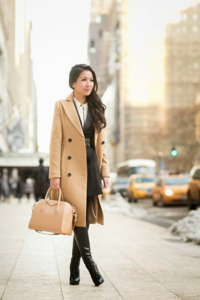 Camel colored mid length double breasted wool coat with thigh high leather boots
