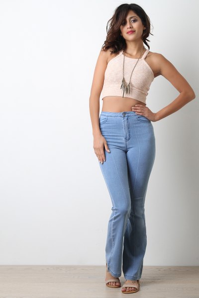 Cropped, fitted pale pink tank top with light blue high-rise jeans
