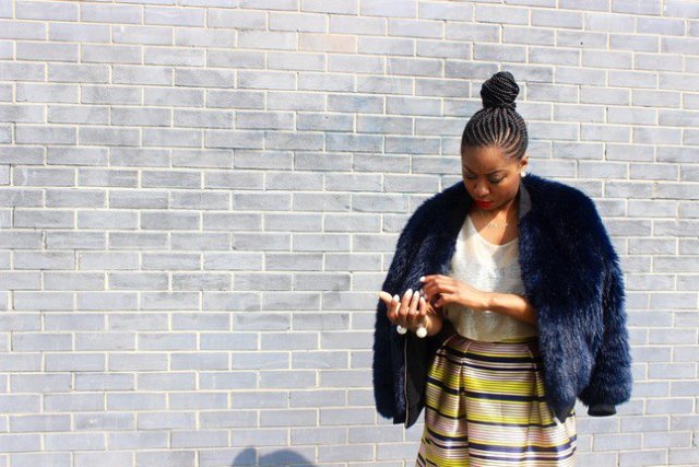 Dark faux fur bomber jacket with yellow and blue high waist midi skirt