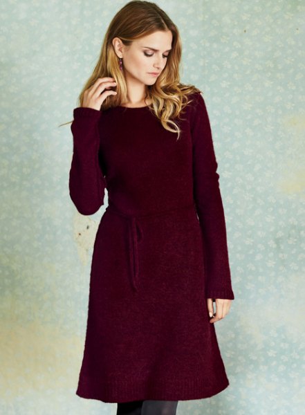 Deep red belted long sleeve sweater dress with skinny jeans