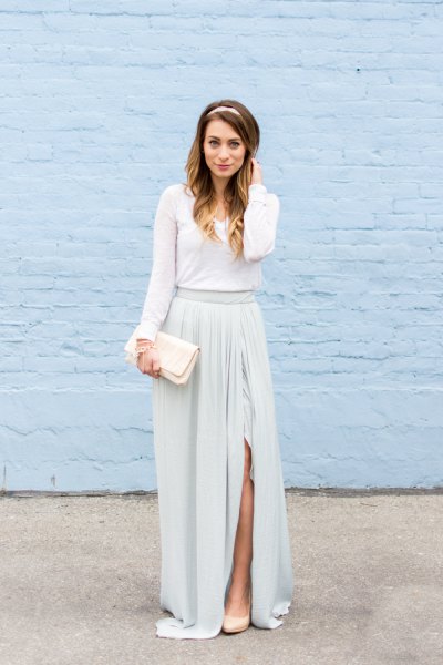 Floor-length dress with a gathered waist, long sleeves and a white clutch bag