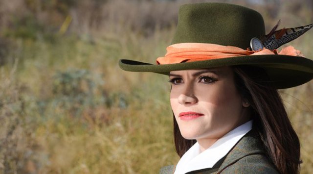 green bush hat with tweed jacket and white collared shirt
