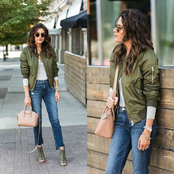 Green flight jacket with gray long sleeve t-shirt and short jeans