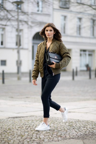 green quilted pilot jacket with black cuffed jeans and white sneakers