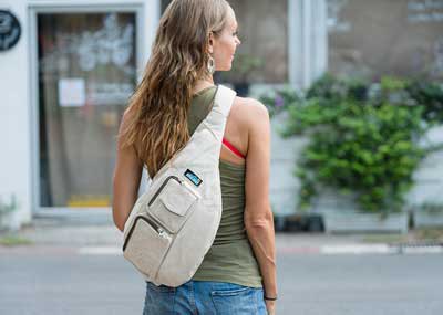 green tank top with ivory shoulder bag and light blue jeans