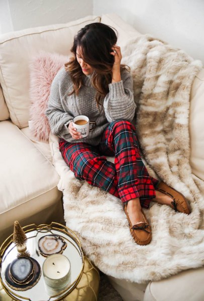 gray cable knit sweater with red and blue checked pajama
bottoms
