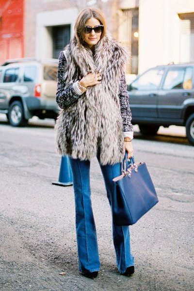 gray long vest with blue flared jeans and dark blue handbag