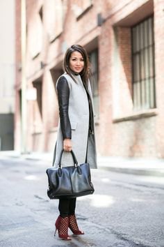 Gray mid-length sleeveless wool coat over a black leather jacket