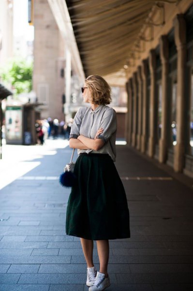 gray polo shirt with black high-waisted midi flared skirt and white comfortable walking shoes
