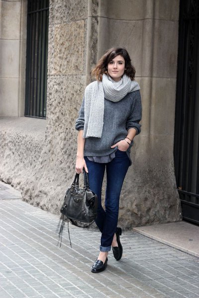 Gray ribbed bulky sweater with dark cuffed jeans and leather loafers