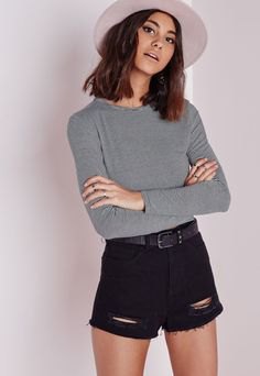 gray sweater with black ripped shorts and white felt hat