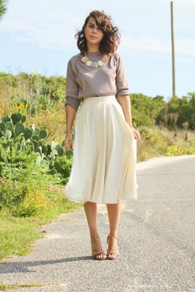 Gray sweater with statement necklace and white flowy midi skirt