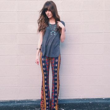 gray t-shirt with navy blue and orange flared pants with tribal print
