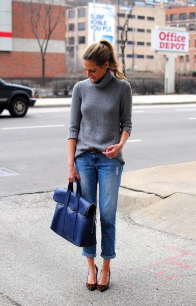 gray knit turtleneck with blue cuffed jeans and matching briefcase