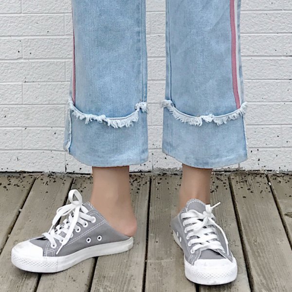 Light blue pleated cuffed cropped jeans with gray and white canvas sneakers