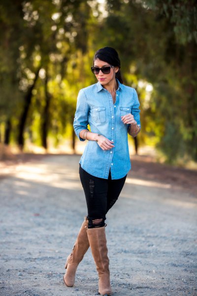 Light blue denim shirt with black ripped jeans and camel heel knee high boots
