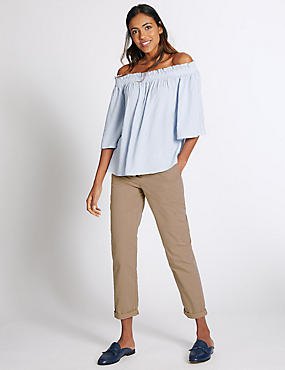 Light blue off the shoulder blouse with beige cuffed slim fit chinos