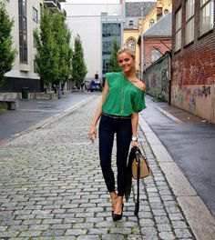 Light emerald green one shoulder top with black ankle length skinny jeans