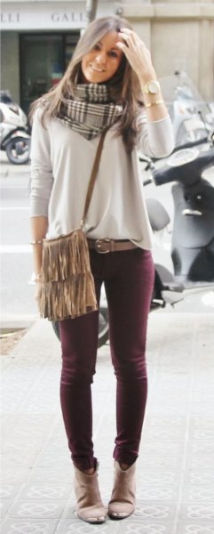 Light gray sweater with skinny jeans and fringed shoulder bag