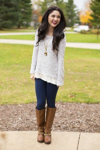 mottled light gray tunic sweater with dark blue leggings and brown leather boots