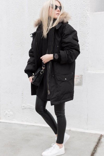 long oversized black winter coat with dark gray skinny jeans and white sneakers