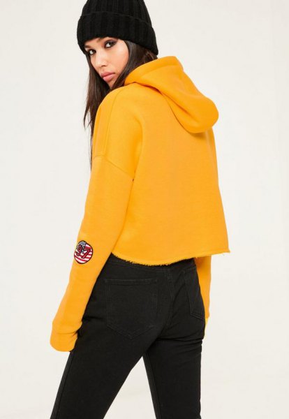 mustard yellow cropped hoodie with black high waist jeans