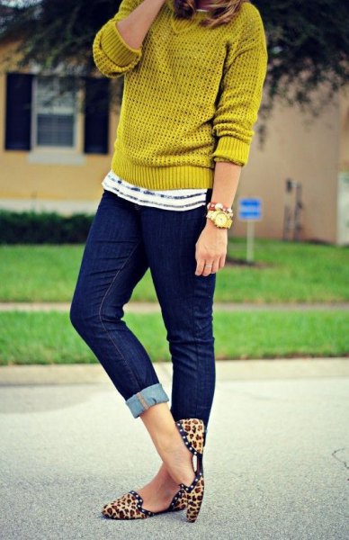 Mustard yellow sweater with dark blue cuffed skinny jeans and animal print flats