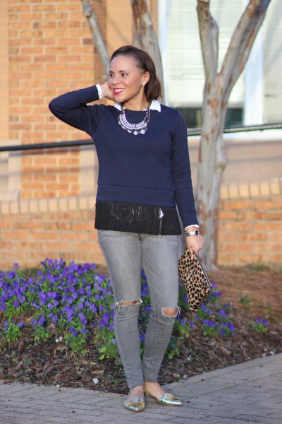 Navy blue sweater with fringes and gray ripped jeans
