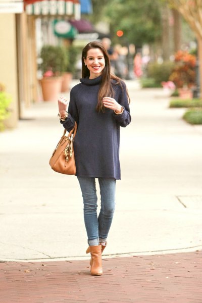 Navy long sleeve turtleneck tunic with cuffed jeans and orange boots