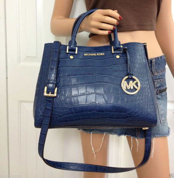 dark blue leather handbag with green crop top and mini shorts