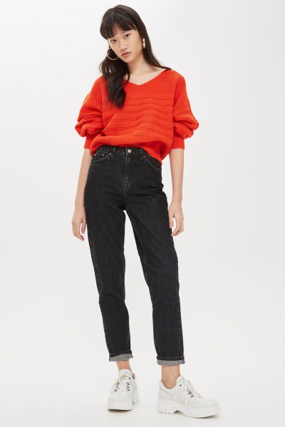 Orange chunky knit v-neck sweater and black mom jeans