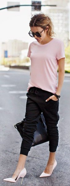Light pink t-shirt with black jogging shorts and white high heels
