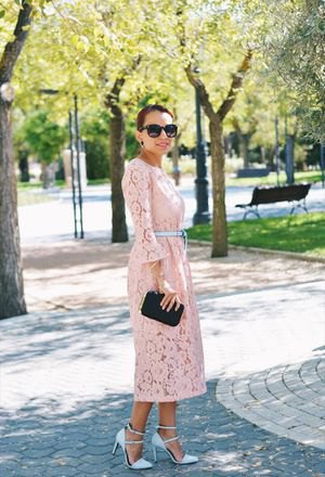 Light yellow lace maxi dress with bell sleeves and belt, and pink strappy heels