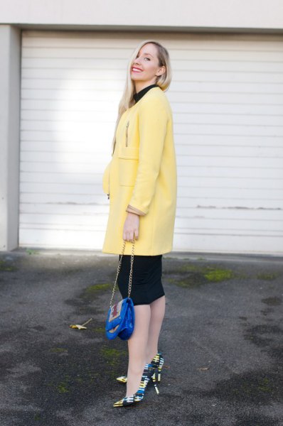 light yellow long wool coat with black knee-length shift dress
