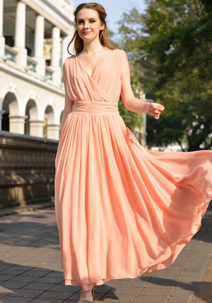 Peach colored long flowy dress with deep V-neckline and gathered waist