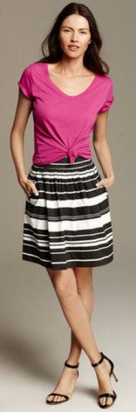 Pink knotted scoop neck t-shirt with black and white striped knee length skirt