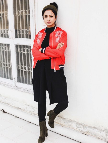 Red embroidered bomber jacket with black crew neck sweater and skinny jeans