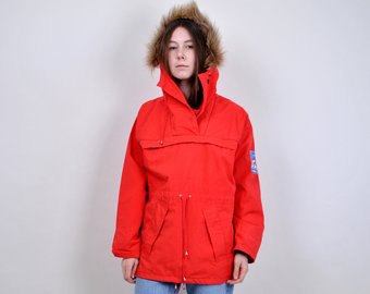 Red faux fur hooded windbreaker and light blue jeans