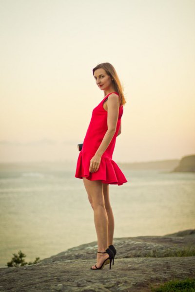Red fishtail sleeveless mini dress with black heels