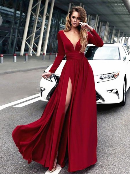 Red maxi prom dress with a deep V-neckline and long sleeves and a high slit