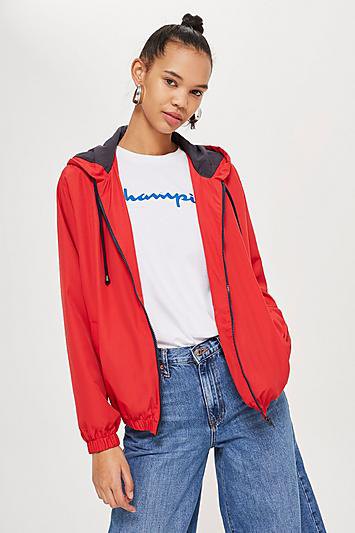 Red windbreaker with white printed t-shirt and flared jeans