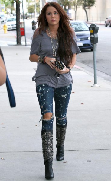 Ripped skinny jeans in a patent look and knee-high black leather boots