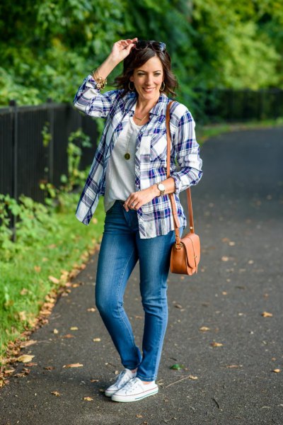 Pair a scoop neck t-shirt with blue jeans and white low top sneakers