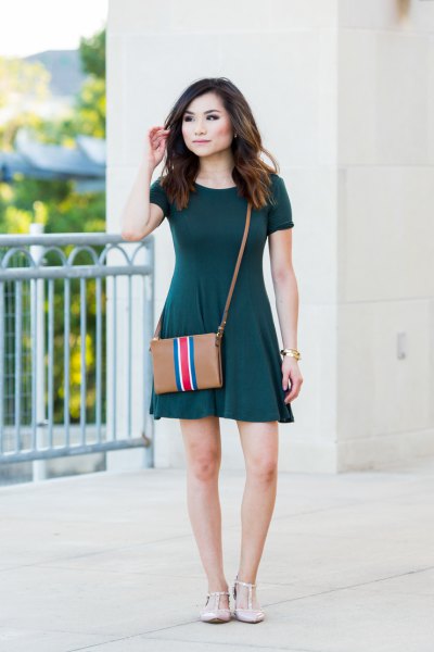 Dark green mini skater dress with short sleeves and brown leather shoulder bag