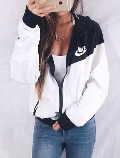 White and black Nike windbreaker with a low-cut tank top and jeans