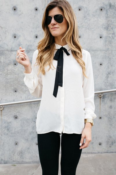 White and black chiffon shirt with tie collar and wide waistband and skinny jeans