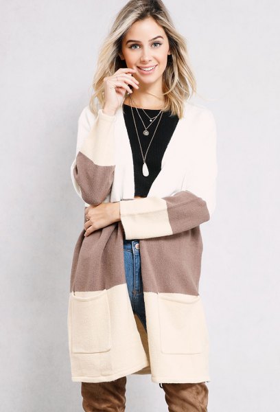 White and gray color block long cardigan with blue jeans and camel long boots