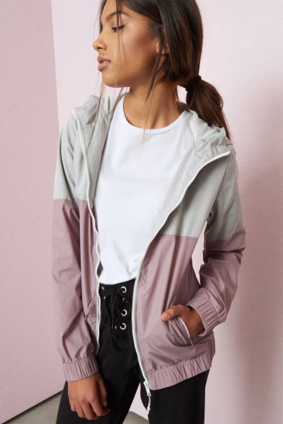 White and light gray color block windbreaker jacket from Nike worn with black lace-up jeans