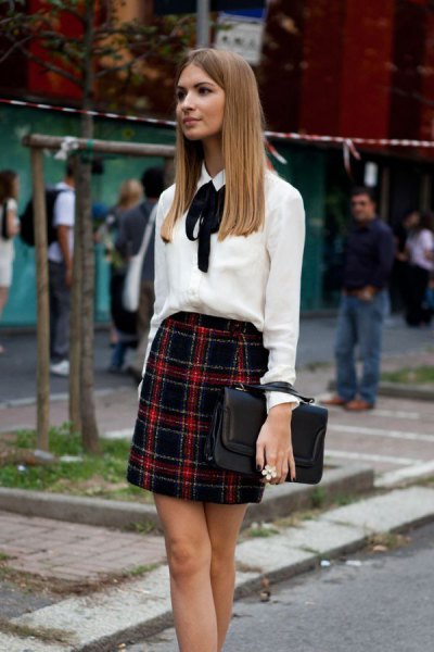 White blouse with bow tie and red and black checked mini skirt